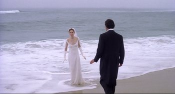 Movie still from “Birth” (2004), directed by Jonathan Glazer – A man and woman in wedding attire standing on the beach; Wide shot, High angle