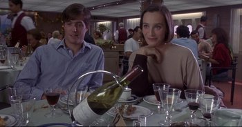 Movie still from “Bitter Moon” (1992), directed by Roman Polanski – A man and a woman sitting at a dinner table; Medium shot, High angle