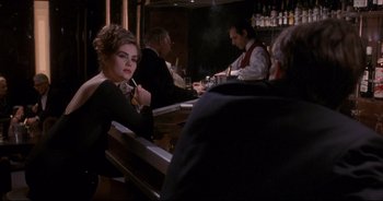 Movie still from “Bitter Moon” (1992), directed by Roman Polanski – A group of people sitting at a bar drinking and smoking; Medium shot, Over the shoulder angle
