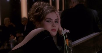 Movie still from “Bitter Moon” (1992), directed by Roman Polanski – A woman sitting at a table with a glass of orange juice; Close Up shot, High angle