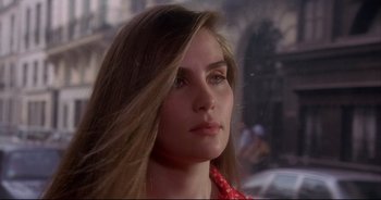 Movie still from “Bitter Moon” (1992), directed by Roman Polanski – A beautiful young woman with long brown hair and wearing a red scarf; Close Up shot, Over the shoulder angle