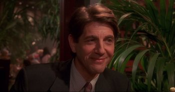 Movie still from “Bitter Moon” (1992), directed by Roman Polanski – A person wearing a suit and tie; Close Up shot, Over the shoulder angle