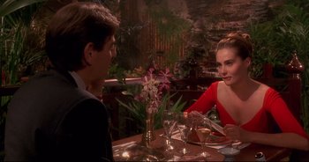 Movie still from “Bitter Moon” (1992), directed by Roman Polanski – A man and a woman sitting at a dinner table; Medium shot, Over the shoulder angle