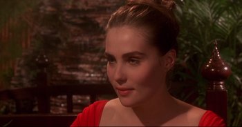 Movie still from “Bitter Moon” (1992), directed by Roman Polanski – A woman in a red shirt is sitting outside; Close Up shot, Over the shoulder angle
