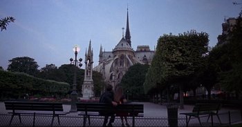 Movie still from “Bitter Moon” (1992), directed by Roman Polanski – Two people sitting on a bench in front of a cathedral; Wide shot, Low angle