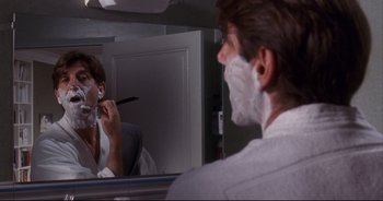 Movie still from “Bitter Moon” (1992), directed by Roman Polanski – A man shaving in front of a mirror in a bathroom; Close Up shot, Over the shoulder angle