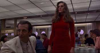 Movie still from “Bitter Moon” (1992), directed by Roman Polanski – A woman in a red dress standing next to a man in a suit; Medium shot, Low angle