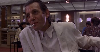 Movie still from “Bitter Moon” (1992), directed by Roman Polanski – A man in a white suit is smoking a cigarette; Close Up shot, Low angle
