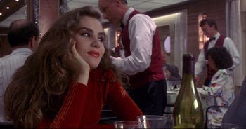 Movie still from “Bitter Moon” (1992), directed by Roman Polanski – A woman sitting at a table with a glass of wine in front of a man; Close Up shot, Over the shoulder angle