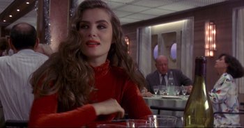 Movie still from “Bitter Moon” (1992), directed by Roman Polanski – A woman sitting at a table with a man sitting at a table; Medium shot, Over the shoulder angle