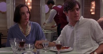 Movie still from “Bitter Moon” (1992), directed by Roman Polanski – A man and a woman sitting at a dinner table; Medium shot, Over the shoulder angle