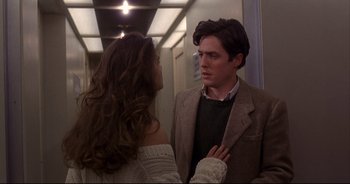 Movie still from “Bitter Moon” (1992), directed by Roman Polanski – A man and a woman are talking in a hallway; Medium shot, Over the shoulder angle