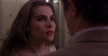 Movie still from “Bitter Moon” (1992), directed by Roman Polanski – A woman with red lipstick looking at a man in a suit; Close Up shot, Over the shoulder angle