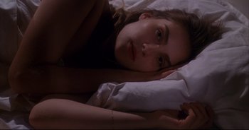 Movie still from “Bitter Moon” (1992), directed by Roman Polanski – A woman laying in a bed with her head on her pillow; Close Up shot, High angle