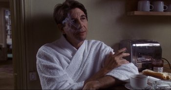 Movie still from “Bitter Moon” (1992), directed by Roman Polanski – A man sitting in a white robe smoking a cigarette; Medium shot, Low angle