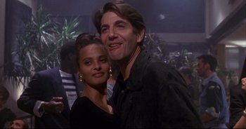 Movie still from “Bitter Moon” (1992), directed by Roman Polanski – A man and a woman posing for a picture; Medium shot, Low angle