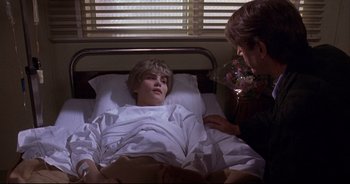 Movie still from “Bitter Moon” (1992), directed by Roman Polanski – A young boy laying in a hospital bed with his mother; Medium shot, Over the shoulder angle