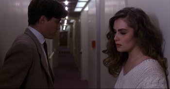 Movie still from “Bitter Moon” (1992), directed by Roman Polanski – A man and a woman standing next to each other in a hallway; Medium shot, Over the shoulder angle