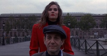 Movie still from “Bitter Moon” (1992), directed by Roman Polanski – A man and a woman standing next to each other on a street; Medium shot, Low angle