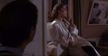 Movie still from “Bitter Moon” (1992), directed by Roman Polanski – A woman sitting on a chair talking on the phone; Medium shot, High angle