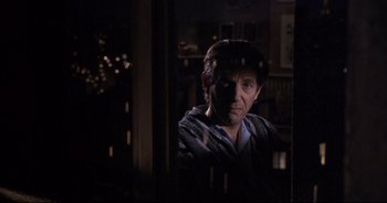 Movie still from “Bitter Moon” (1992), directed by Roman Polanski – A man sitting in front of a window in a dark room; Close Up shot, Over the shoulder angle