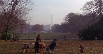Movie still from “Bitter Moon” (1992), directed by Roman Polanski – People are sitting on a bench in a park; Extreme Wide shot, High angle