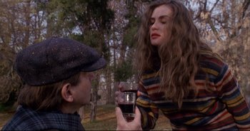 Movie still from “Bitter Moon” (1992), directed by Roman Polanski – A man and a woman are holding a glass of wine; Medium shot, Over the shoulder angle