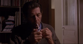 Movie still from “Bitter Moon” (1992), directed by Roman Polanski – A person lighting a cigarette; Medium shot, High angle