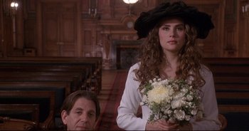 Movie still from “Bitter Moon” (1992), directed by Roman Polanski – A woman holding a bouquet of flowers in a church; Close Up shot, Over the shoulder angle