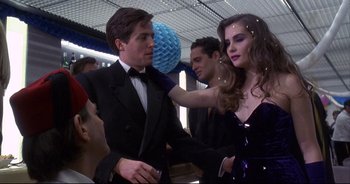 Movie still from “Bitter Moon” (1992), directed by Roman Polanski – A man and a woman in formal wear at an event; Medium shot, Over the shoulder angle
