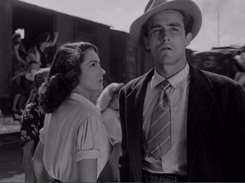 Movie still from “Bitter Rice” (1949), directed by Giuseppe De Santis – A man and a woman standing next to each other; Medium shot, Low angle