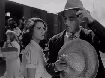 Movie still from “Bitter Rice” (1949), directed by Giuseppe De Santis – A man and a woman standing next to each other; Close Up shot, Low angle