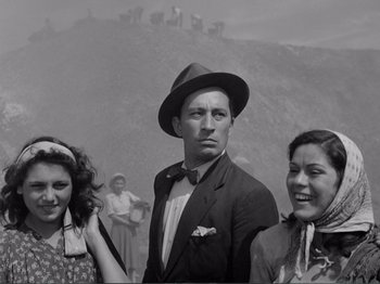 Movie still from “Bitter Rice” (1949), directed by Giuseppe De Santis – A black and white photo of a man and two women; Medium shot, Low angle