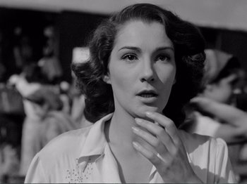 Movie still from “Bitter Rice” (1949), directed by Giuseppe De Santis – An old photo of a beautiful woman with her hand on her chin; Close Up shot, Low angle