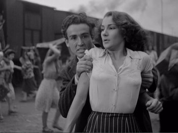 Movie still from “Bitter Rice” (1949), directed by Giuseppe De Santis – A man and a woman are dancing together in a black and white photo; Medium shot, Low angle
