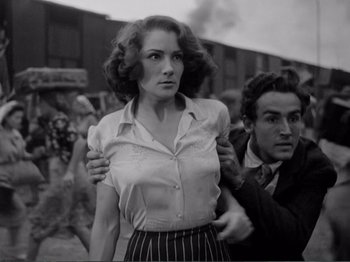 Movie still from “Bitter Rice” (1949), directed by Giuseppe De Santis – An old photo of a man and a woman; Medium shot, Over the shoulder angle