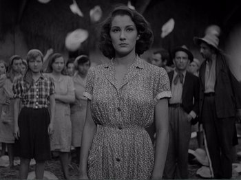 Movie still from “Bitter Rice” (1949), directed by Giuseppe De Santis – A woman standing in front of a group of people; Medium shot, Low angle