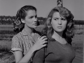 Movie still from “Bitter Rice” (1949), directed by Giuseppe De Santis – Two women standing next to each other on a field; Medium shot, Low angle