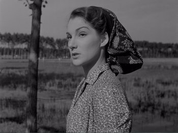 Movie still from “Bitter Rice” (1949), directed by Giuseppe De Santis – A black and white photo of a woman wearing a head scarf; Close Up shot, Low angle