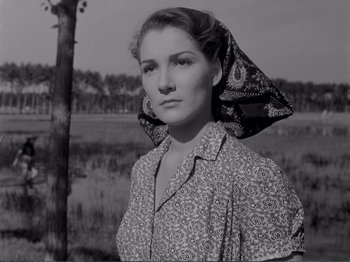 Movie still from “Bitter Rice” (1949), directed by Giuseppe De Santis – A black and white photo of a woman wearing a head scarf; Close Up shot, Low angle