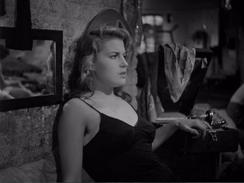 Movie still from “Bitter Rice” (1949), directed by Giuseppe De Santis – A woman sitting in front of a laptop computer; Close Up shot, High angle