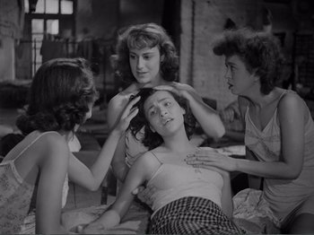 Movie still from “Bitter Rice” (1949), directed by Giuseppe De Santis – A group of young women sitting around a woman's hair; Medium shot, High angle