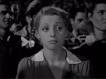 Movie still from “Bitter Rice” (1949), directed by Giuseppe De Santis – A black and white photo of a woman with flowers in her hair; Close Up shot, Low angle