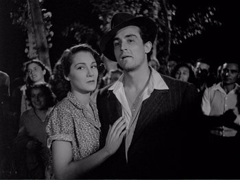 Movie still from “Bitter Rice” (1949), directed by Giuseppe De Santis – A man and a woman standing next to each other in a crowd; Medium shot, Low angle