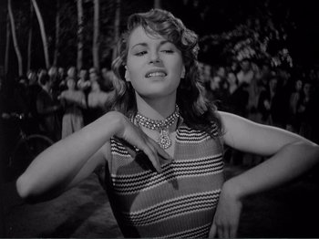 Movie still from “Bitter Rice” (1949), directed by Giuseppe De Santis – A black - and - white photo of a woman in a striped dress; Medium shot, Low angle
