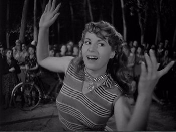 Movie still from “Bitter Rice” (1949), directed by Giuseppe De Santis – An old photo of a woman waving her hands; Medium shot, Low angle