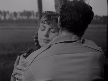 Movie still from “Bitter Rice” (1949), directed by Giuseppe De Santis – A man and a woman embracing each other; Close Up shot, High angle