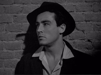 Movie still from “Bitter Rice” (1949), directed by Giuseppe De Santis – A black and white photo of a man wearing a hat; Close Up shot, Low angle