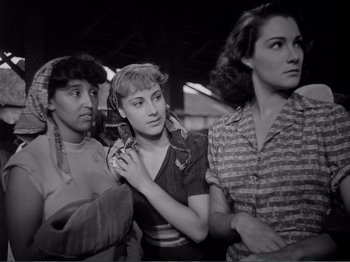 Movie still from “Bitter Rice” (1949), directed by Giuseppe De Santis – A group of women standing next to each other in a room; Medium shot, Low angle