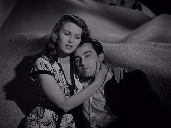 Movie still from “Bitter Rice” (1949), directed by Giuseppe De Santis – A man and a woman sitting next to each other on a couch; Medium shot, High angle